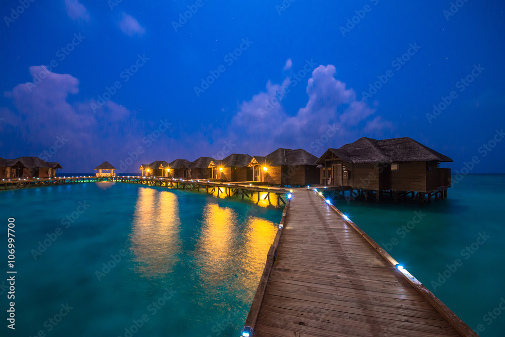 Fototapeta premium Over water bungalows with steps into amazing green lagoon 