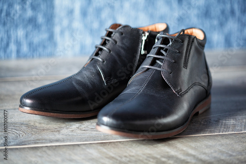 a pair of new leather men's shoes on a wooden background