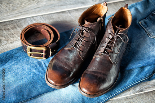 still life of garments - jeans, leather shoes and belt with buckle