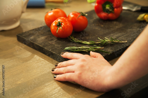 womans hands near the board with vegetables