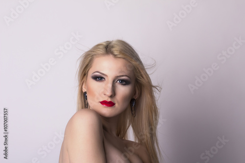 Pretty blonde woman face over a grey background