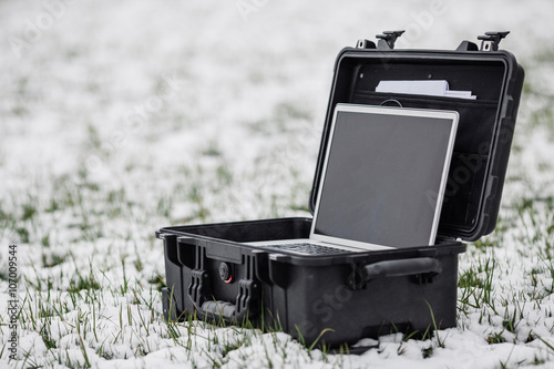 Opened plastic protector case with laptop lying on the grass photo