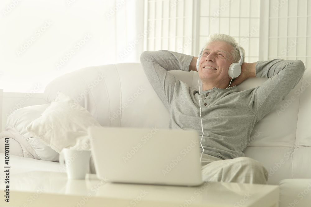 senior man in headphones with laptop senior man in headphones with laptop