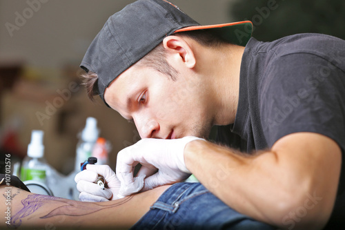 Tattooist makes tattoo, clo...