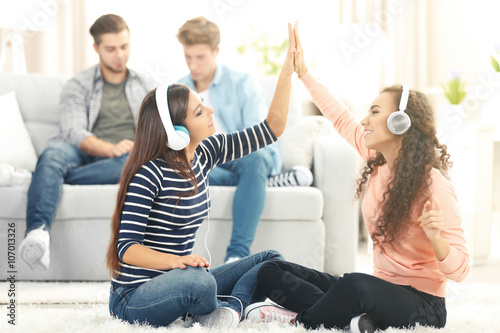 Two teenager girls listenin...
