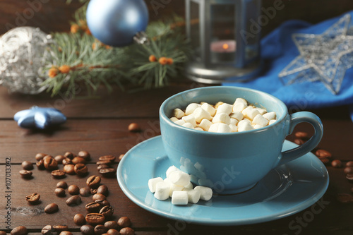 Mug of hot chocolate with marshmallows, fir tree branch on wooden background