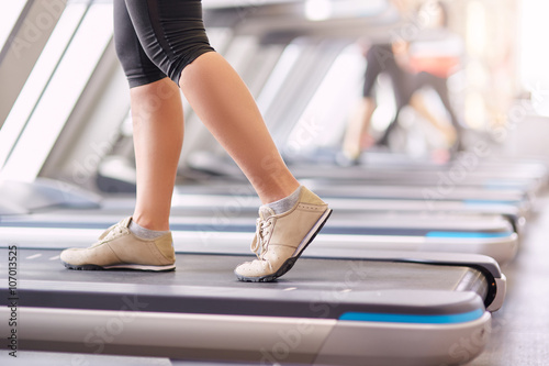 woman's muscular legs on treadmill, closeup