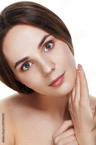 Closeup Beautiful face of young woman with clean fresh skin. Portrait woman touch her face by hands with beautiful blue eyes on white background. Beautiful woman with natural make-up. 