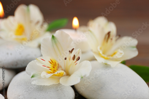 Spa still life with stones  flowers and candlelight closeup