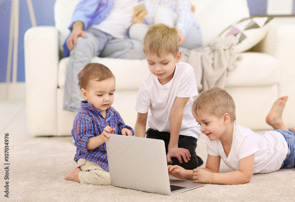 Family concept. Brothers with laptop on the floor in the room Family concept. Brothers with laptop on the floor in the room