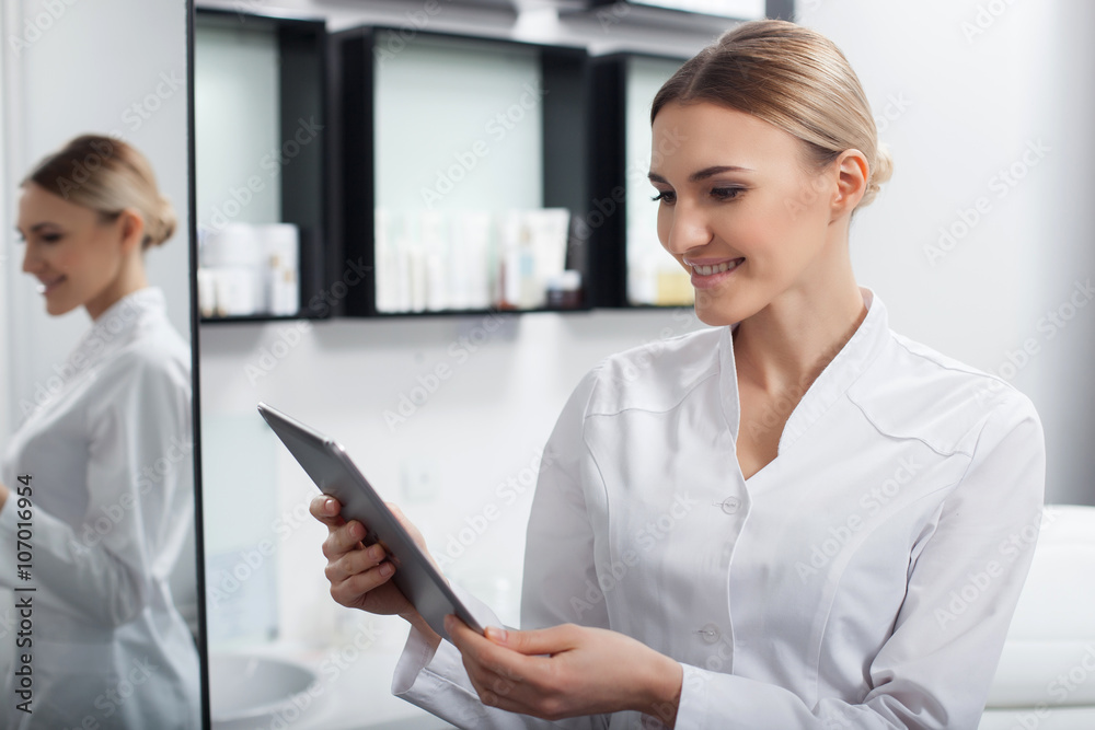 Professional young beautician is working with technology Professional young beautician is working with technology