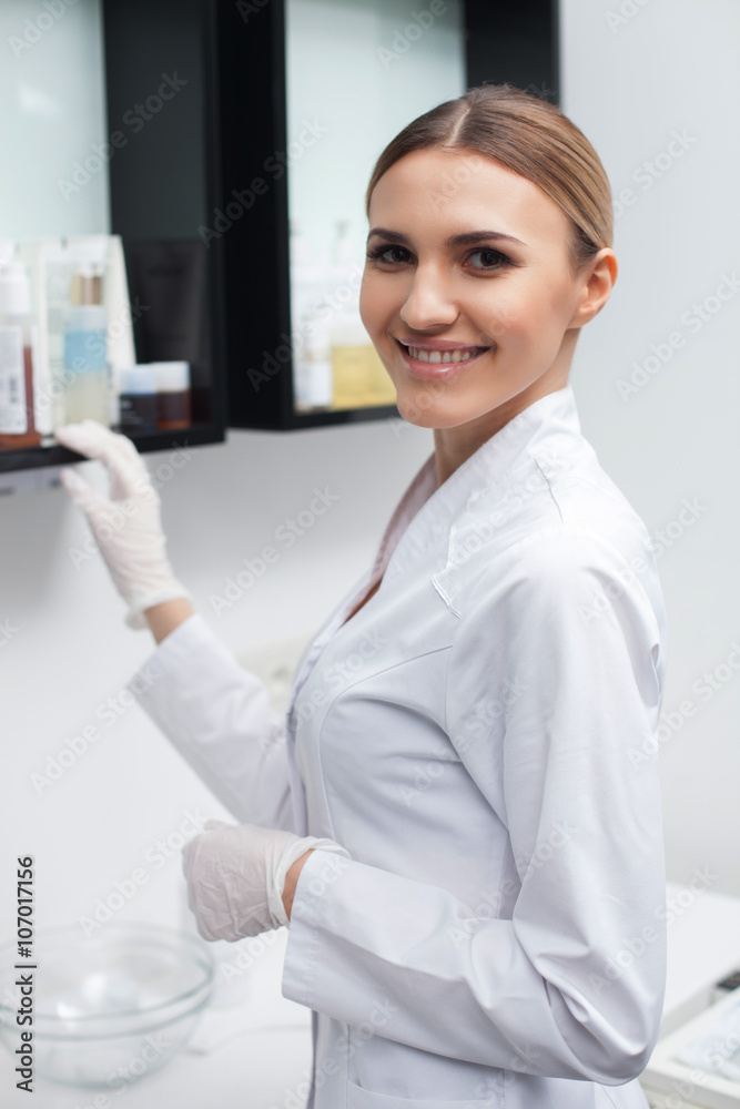 Cheerful female beautician is working with cosmetology Cheerful female beautician is working with cosmetology