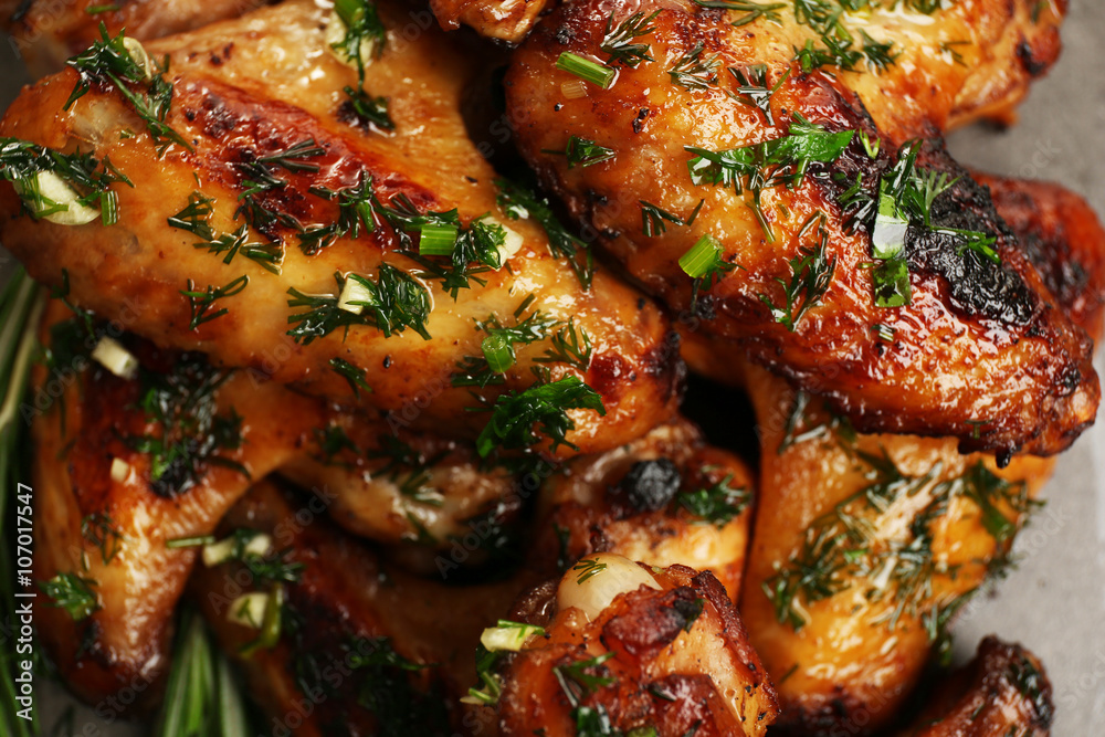 Baked chicken wings with spices on grey background