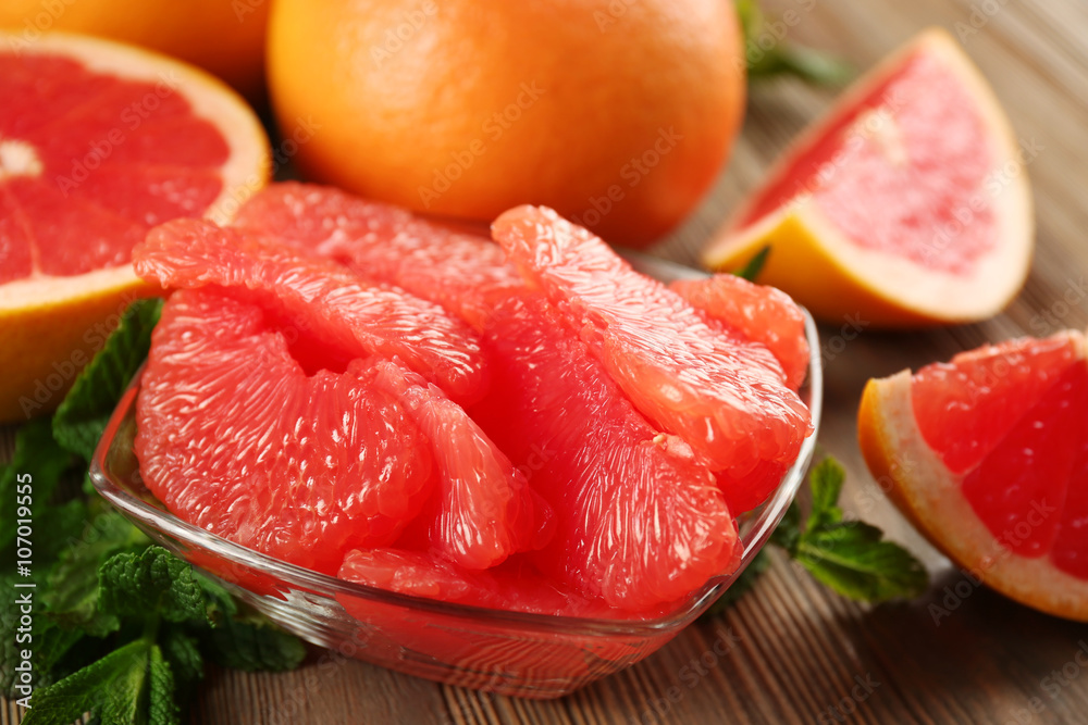 Juicy grapefruit pieces with fresh mint in a bowl, close up Juicy grapefruit pieces with fresh mint in a bowl, close up