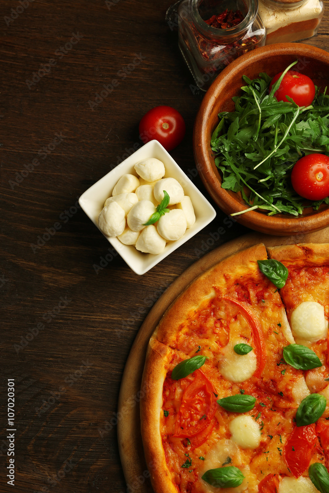 Margherita pizza with tomatoes, basil and Mozzarella on wooden background Margherita pizza with tomatoes, basil and Mozzarella on wooden background