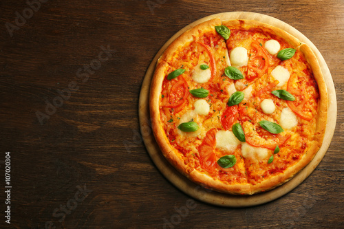 Margherita pizza on wooden background