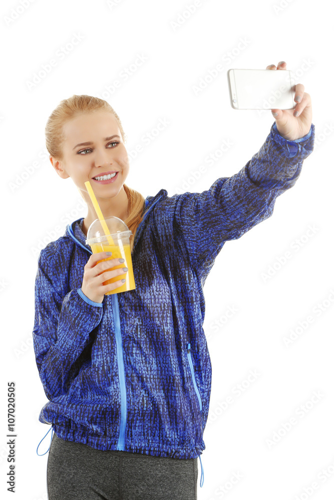 Young woman making selfie photo with plastic cup of orange juice isolated on white Young woman making selfie photo with plastic cup of orange juice isolated on white