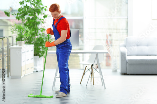 Young janitor with brush cl...