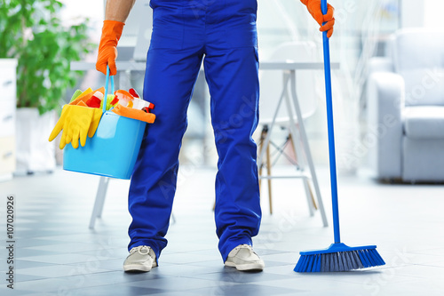 Young janitor holding clean...