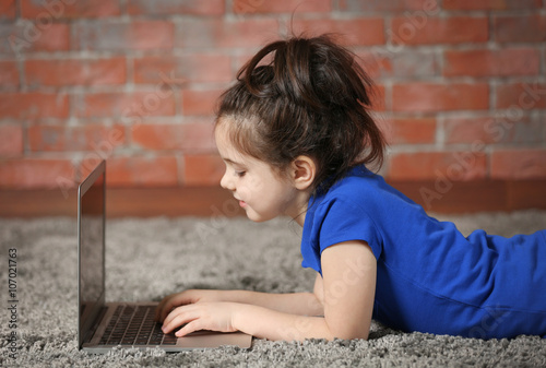 Little girl using laptop on...