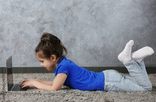 Little girl using laptop on...