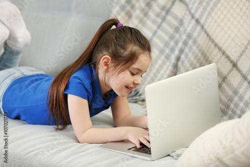 Little girl using laptop on...