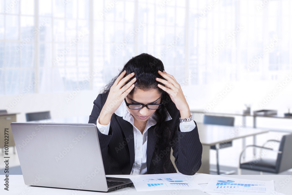 Tired Indian businesswoman in workplace Tired Indian businesswoman in workplace