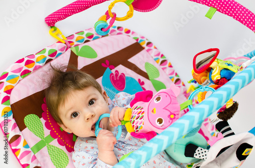 baby girl playing in an activity gym