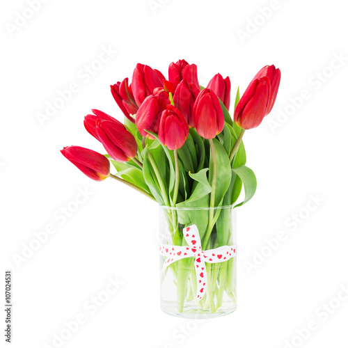 Fototapeta Naklejka Na Ścianę i Meble -  Red tulips bouquet in vase decorated with ribbon. Isolated over white background