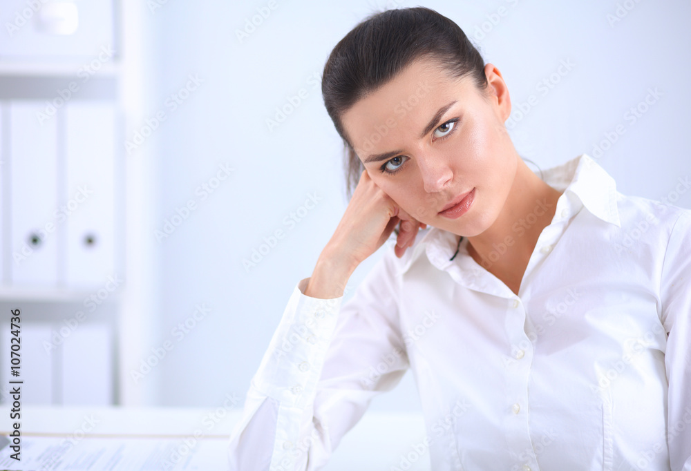 Attractive businesswoman sitting on a desk with laptop in the office Attractive businesswoman sitting on a desk with laptop in the office