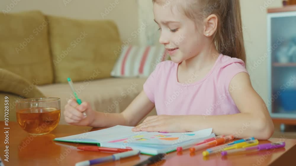 Portrait cute girl 7 years old sitting in the table and smiling at camera Portrait cute girl 7 years old sitting in the table and smiling at camera