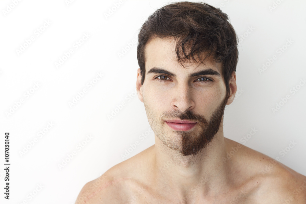 Man without a shirt, standing in front of a camera on a white background with half of his face with scruffy beard and messy hair, the other half has trimmed beards. Man without a shirt, standing in front of a camera on a white background with half of his face with scruffy beard and messy hair, the other half has trimmed beards.