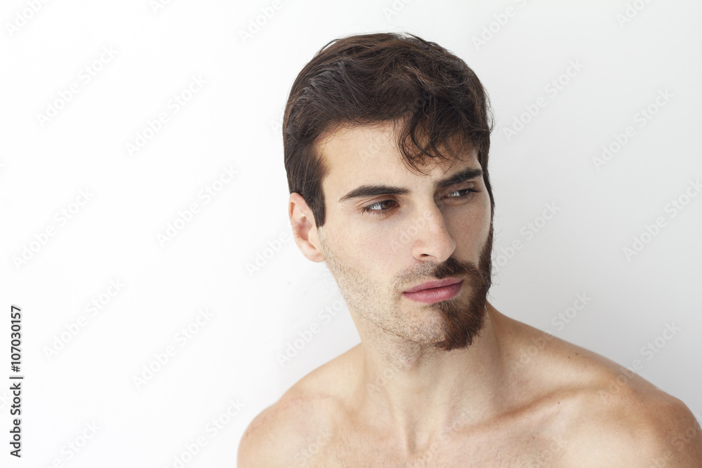 Man without a shirt, standing in front of a camera on a white background with half of his face with scruffy beard and messy hair, the other half has trimmed beards. Man without a shirt, standing in front of a camera on a white background with half of his face with scruffy beard and messy hair, the other half has trimmed beards.