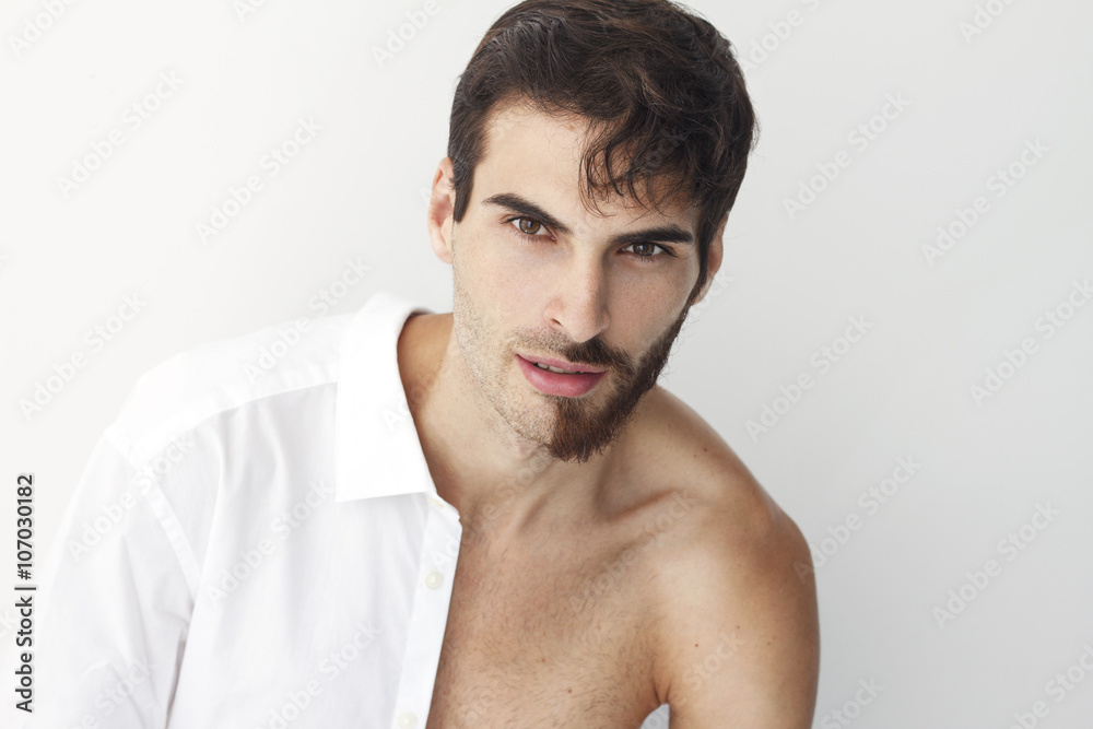 Φωτογραφία Man half dress in white shirt, standing in front of a camera on a white background with half of his face with scruffy beard and messy hair, the other half has trimmed beards