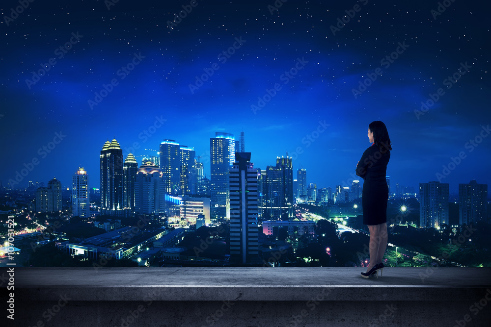 Fototapeta premium Asian business person standing on the rooftop