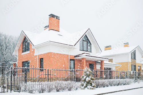 Row of the snowbound houses, homes with the sidewalk on empty strit photo