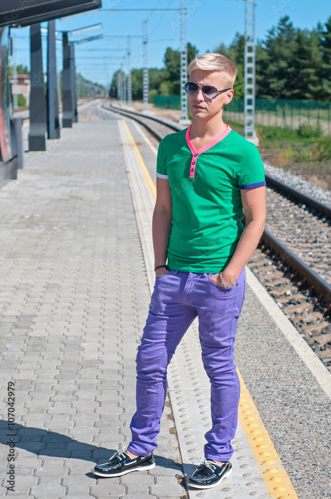 Stylish man in blue standing on train station
