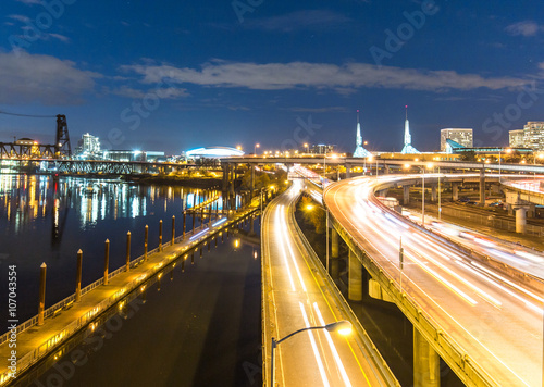 traffic on road with cityscape and skyline of portland at twilig