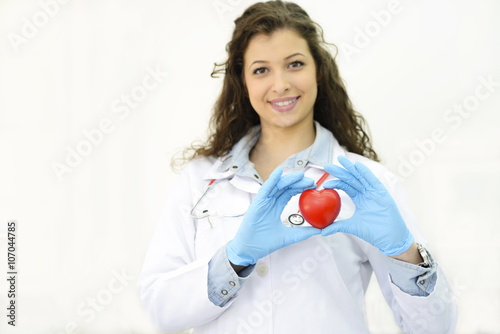 Female doctor's hands holding red heart