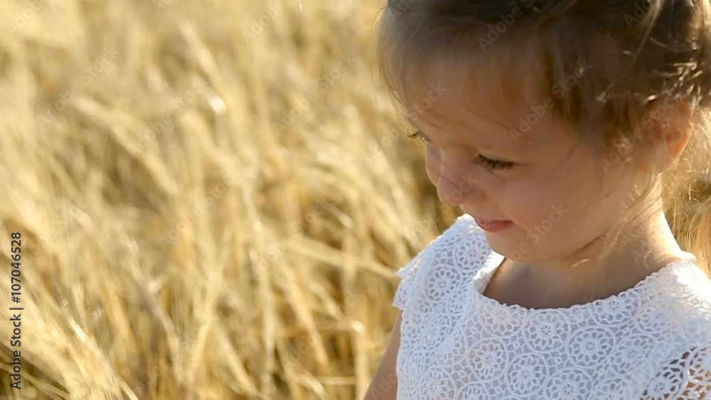 a little girl yells on the field with ears in the evening in summer. slowmotion a little girl yells on the field with ears in the evening in summer. slowmotion