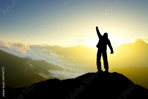Winner silhouette on the mountain top. Sport and active life concept..