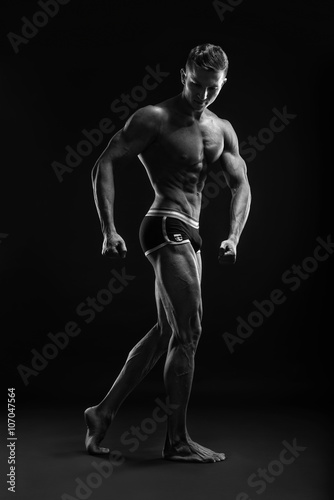 Bodybuilder man posing, showing perfect abs, houlders, biceps, triceps, chest