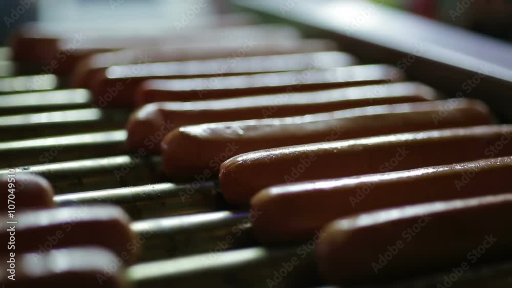 Appetizing hotdog sausages being cooked on grill, snacks at street food festival Appetizing hotdog sausages being cooked on grill, snacks at street food festival