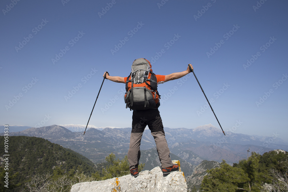 A traveler stands on top of a mountain and looks out to sea. A traveler stands on top of a mountain and looks out to sea.