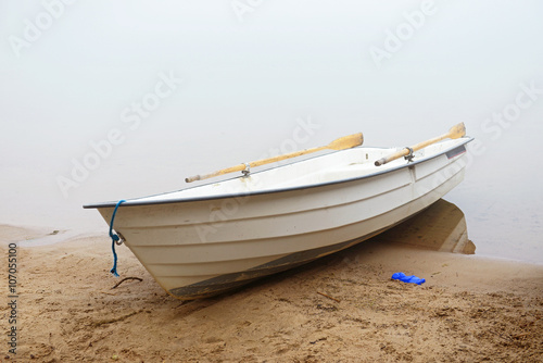 Boat on shore. Early morning fog