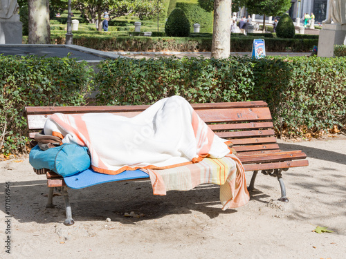 homeless man sleeping on a bench