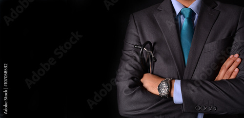 Doctor holding stethoscope in hands black background