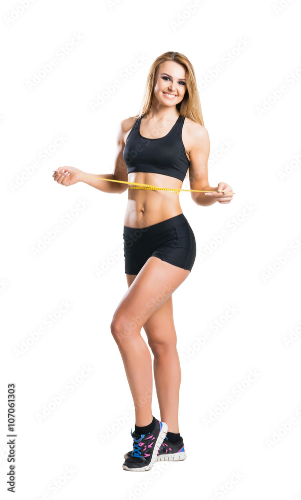 Sporty woman in sportswear measuring her body isolated on white