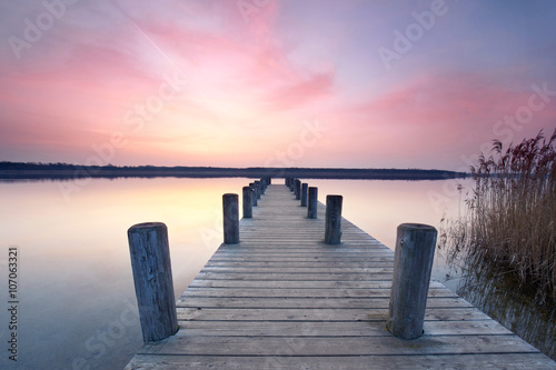 samotny drewniany pomost nad jeziorem - rano o wschodzie słońca