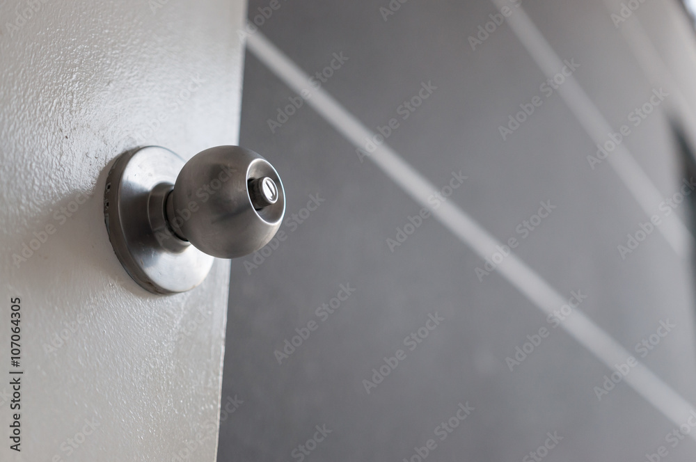 A door knob with a white door on grey wall. A door knob with a white door on grey wall.